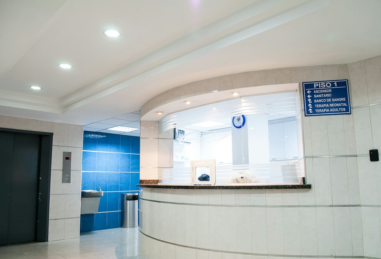 Moderna reception con bancone curvo e piastrelle blu.